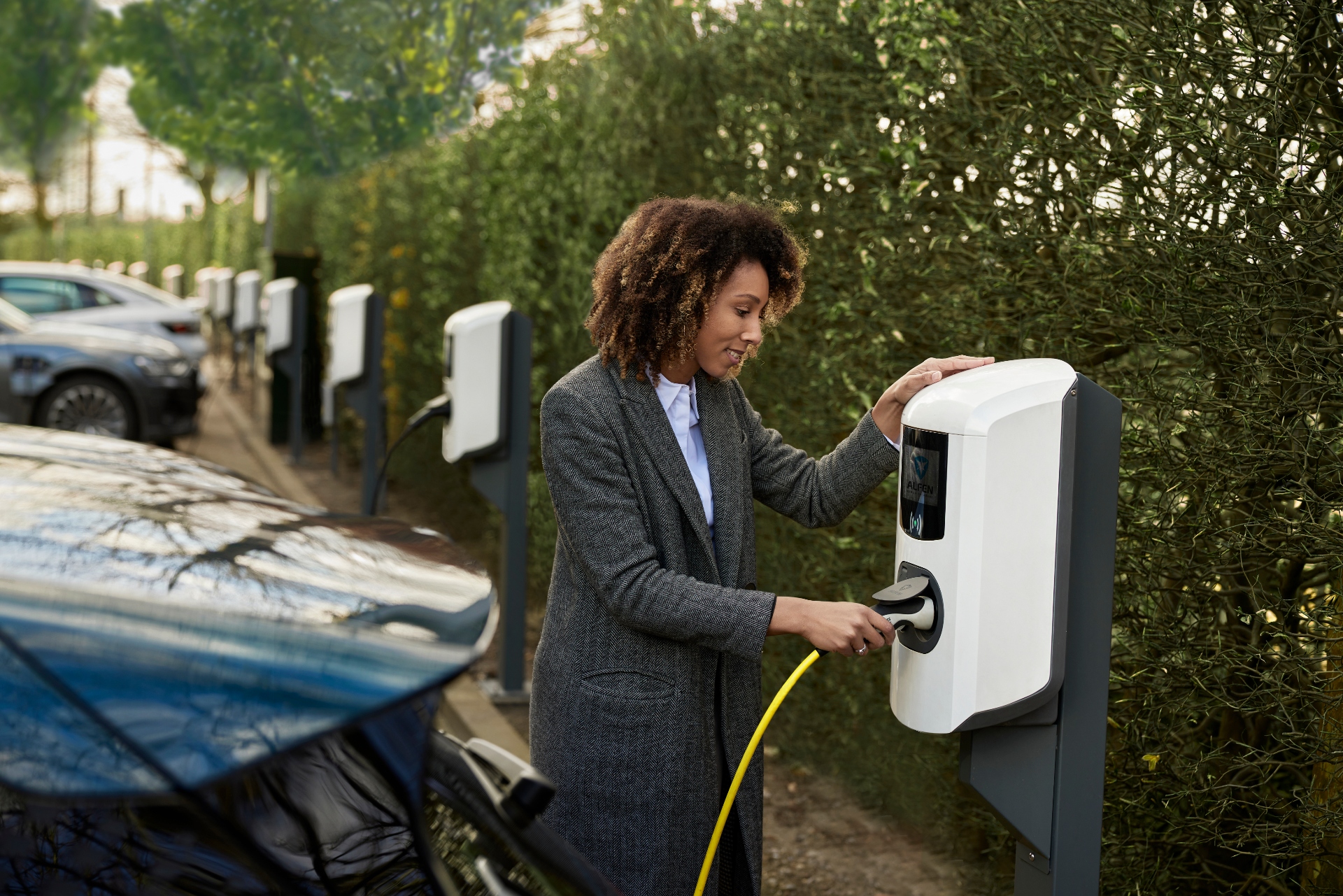 Vrouw die een bidirectionele laadpaal aansluit op een elektrische auto